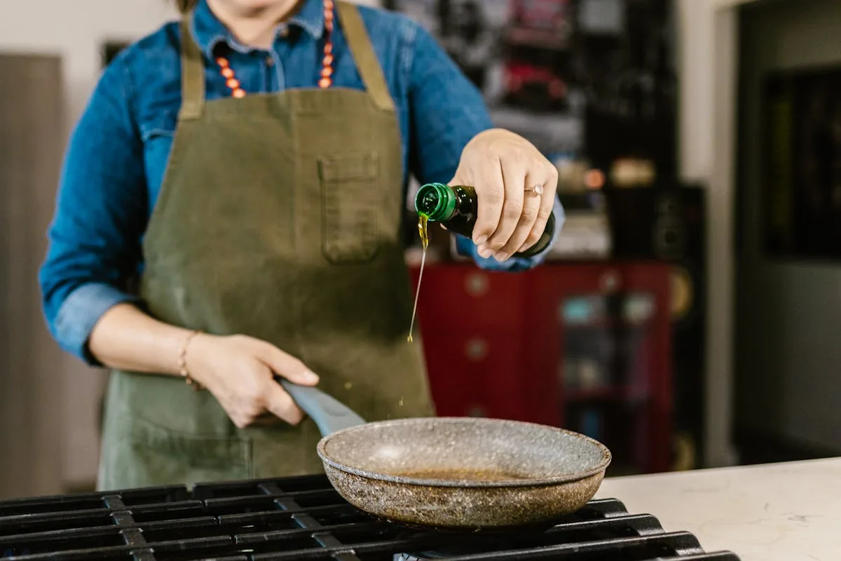 Olive oil for cooking — pouring extra virgin olive oil into a pan